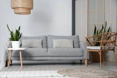 İçinde sehpa, kanepe ve koltuk olan bir oturma odası.