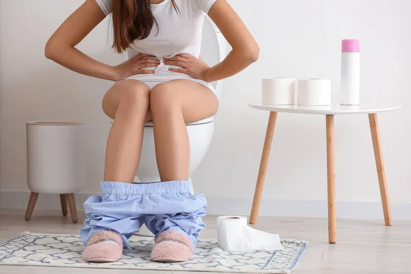 トイレのトイレの上で漂白剤に苦しむ若い女性 — ストック写真