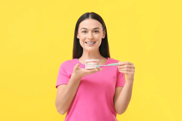 Schöne Frau Mit Zahnspange Zahnbürste Und Kiefermodell Auf Gelbem Hintergrund — Stockfoto