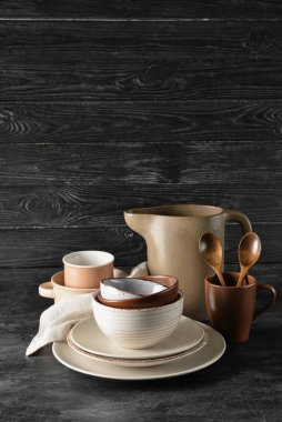 Koyu ahşap arka planda şık yemek takımları.