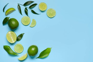 Taze sulu limon ve mavi arkaplanda yapraklar
