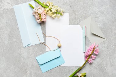 Açık arkaplanda boş kartlar, çiçekler ve kalemler