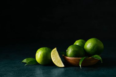 Koyu arkaplanda bir kase taze olgun limon