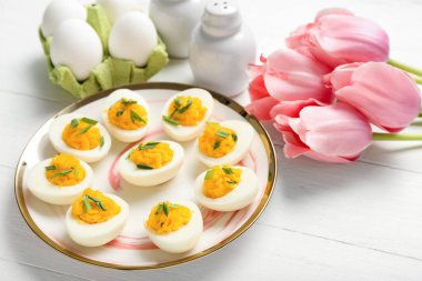 Beyaz ahşap arka planda içi doldurulmuş yumurta tabağı. Paskalya kutlaması