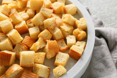 Lezzetli kızarmış ekmek ve arka planda peçete olan kase, yakın plan.