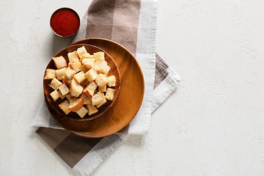 Beyaz arka planda lezzetli kıtır ekmekler, sos ve peçete.