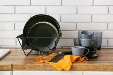 Modern siyah yemek takımı beyaz tuğla duvarın yanında.