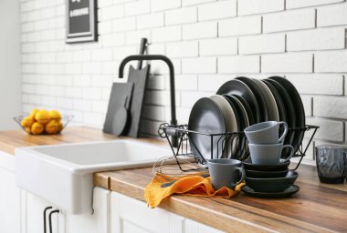 Modern siyah yemek takımı beyaz tuğla duvarın yanında.