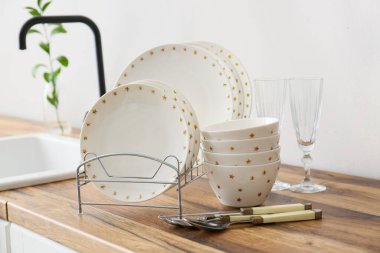 Işık duvarının yanındaki ahşap tezgahta güzel yemek takımı.