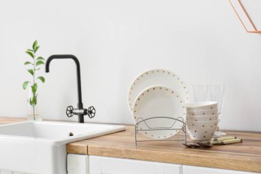 Işık duvarının yanındaki ahşap tezgahta güzel yemek takımı.