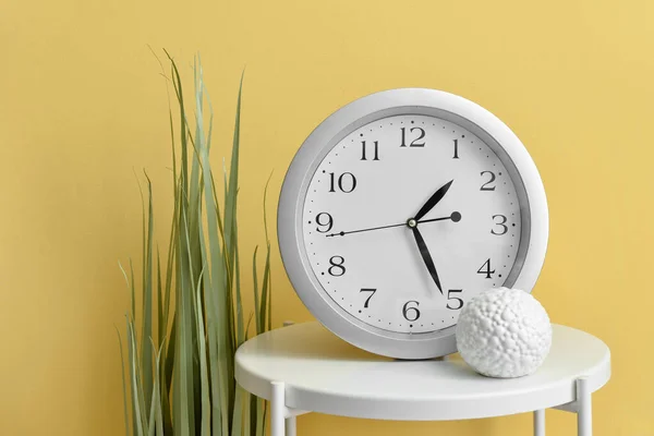 Table Avec Nouvelle Horloge Moderne Plante Intérieur Sur Fond Couleur — Photo