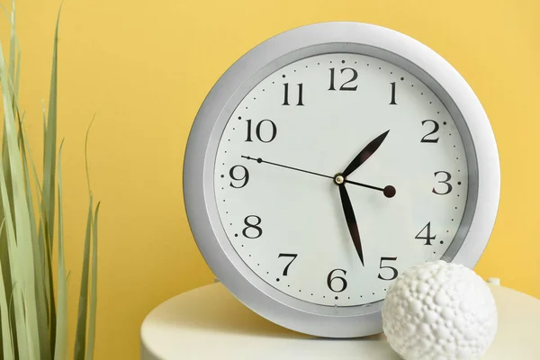 Table Avec Nouvelle Horloge Moderne Plante Intérieur Sur Fond Couleur — Photo