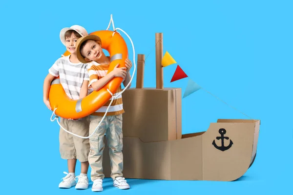 Funny Little Boys Playing Cardboard Ship Lifebuoy Blue Background — Stock Photo, Image