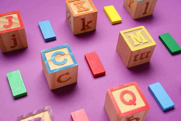 Holzwürfel Mit Buchstaben Und Blöcken Auf Violettem Hintergrund — Stockfoto