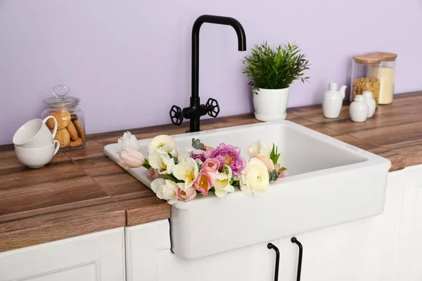 Fregadero Blanco Con Hermosas Flores Utensilios Cocina Mostradores Cerca Pared — Foto de Stock