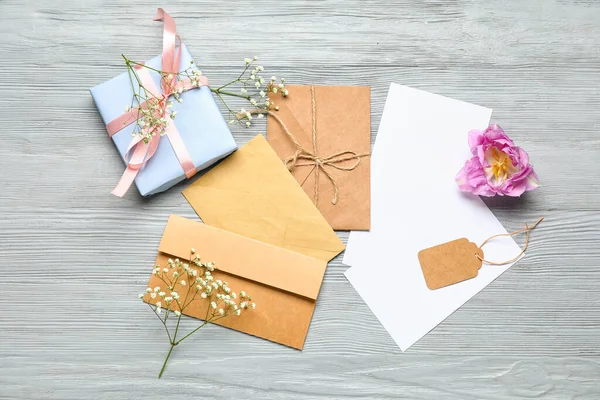 Blank Cards Envelopes Flowers Gift Box Grey Wooden Background — Stock Photo, Image