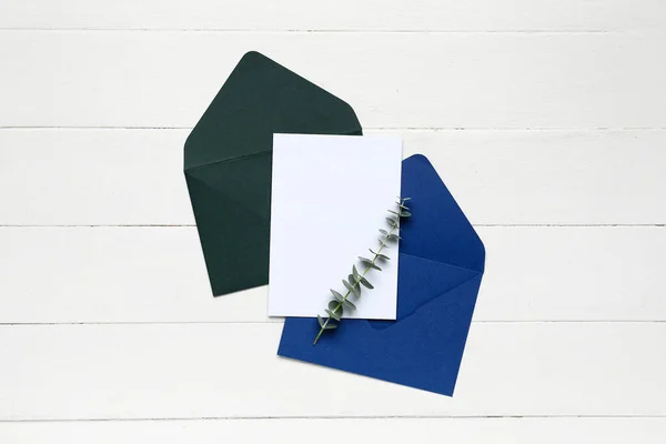Enveloppen Met Blanco Kaart Eucalyptus Tak Witte Houten Ondergrond — Stockfoto
