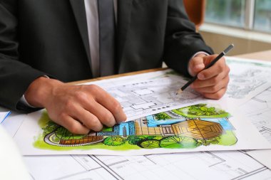 Genç erkek peyzaj tasarımcısı ofiste çalışıyor.