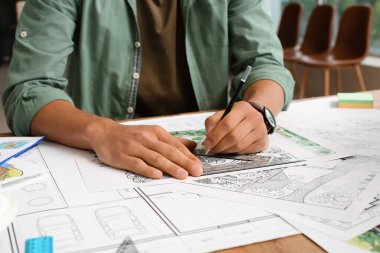 Genç erkek peyzaj tasarımcısı ofiste çalışıyor.