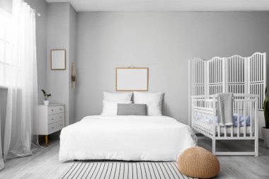 Büyük yataklı, rahat bebek karyolası olan rahat bir odanın modern iç mekanı.