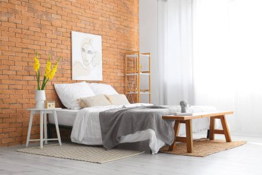 Yatak odasındaki masanın üzerinde güzel gladiolus çiçekleri olan vazo.