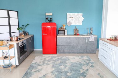 Kırmızı buzdolabı, tezgah ve tahtalı şık bir mutfak.