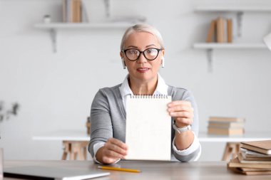 Bayan öğretmen evde ders veriyor.