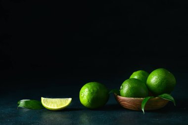 Koyu arkaplanda bir kase olgun limon