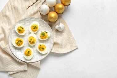 Beyaz arka planda Paskalya yumurtası ve peçeteli tabak.
