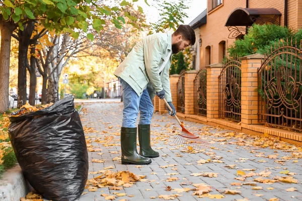Mann Sammelt Herbstblätter Freien — Stockfoto