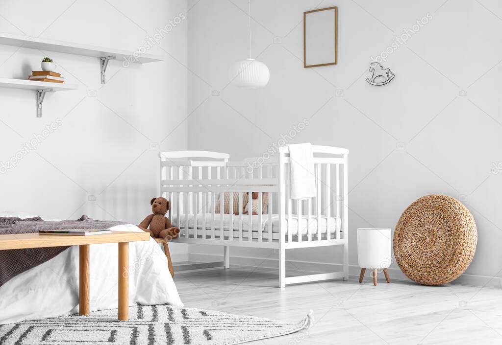 Modern interior of cozy bedroom with comfortable baby crib