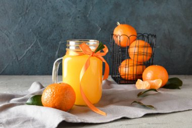 Masada bir kavanoz taze mandalina suyu var.