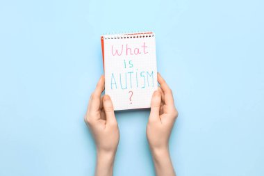 Metinli kadın ve defter. AUTISM nedir? mavi arkaplan