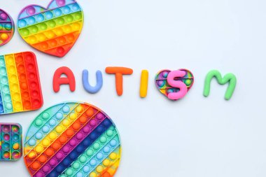 Beyaz arka planda kıpır kıpır oyuncaklarla Kelime AUTISM