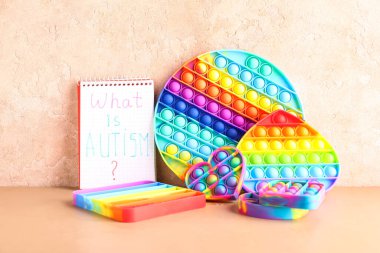 Metinli defter. AUTISM nedir? Renkli arka planda hareketli oyuncaklar.