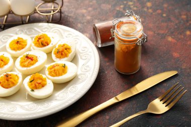 İçi doldurulmuş yumurta, çatal bıçak ve baharatla dolu bir tabak, yakın plan. Paskalya kutlaması