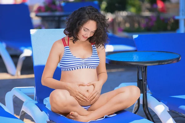 Hamile Kadın Yüzme Havuzunun Yanında Elleri Karnında Kalp Şekli Yapıyor — Stok fotoğraf