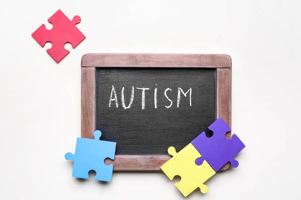 Liitutaulu Sanalla Autism Palapelin Palaset Valkoisella Taustalla — kuvapankkivalokuva
