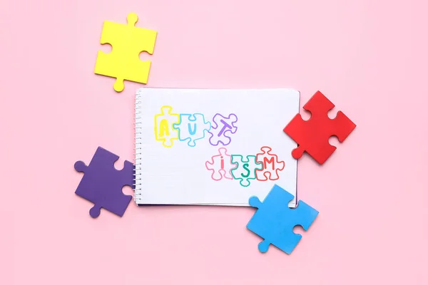 Notizbuch Mit Word Autismus Und Puzzleteilen Auf Rosa Hintergrund — Stockfoto
