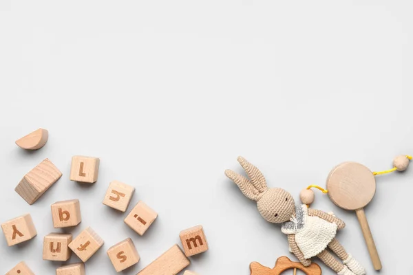 Holzwürfel Mit Buchstaben Und Babyspielzeug Auf Hellem Hintergrund — Stockfoto