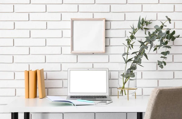 Workplace Laptop Eucalyptus Branches Vase Books White Brick Wall — Stock Photo, Image