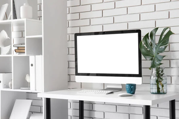 Arbeitsplatz Mit Computer Palmblatt Vase Und Tasse Nahe Weißer Ziegelwand — Stockfoto