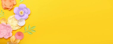 Sarı arkaplanda el yapımı güzel kağıt çiçekler ve metin için yer var.