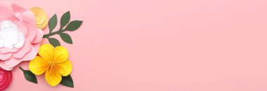 Pembe arkaplanda el yapımı güzel kağıt çiçekler ve metin için yer var.