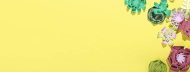 Sarı arkaplanda el yapımı güzel kağıt çiçekler ve metin için yer var.