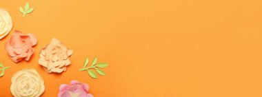 Turuncu arkaplanda el yapımı güzel kağıt çiçekler ve metin için boşluk