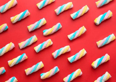 Kırmızı arka planda bir sürü lezzetli marşmelov.