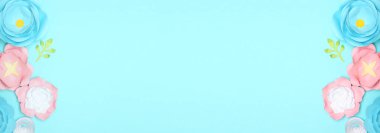 Açık mavi arkaplanda el yapımı güzel kağıt çiçekler ve metin için yer var.