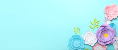 Açık mavi arkaplanda el yapımı güzel kağıt çiçekler ve metin için yer var.