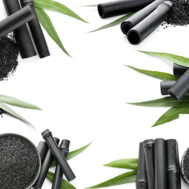 Aktif karbon tozu ve siyah bambu çubukları beyaz zemin üzerinde metin için boşluk ile
